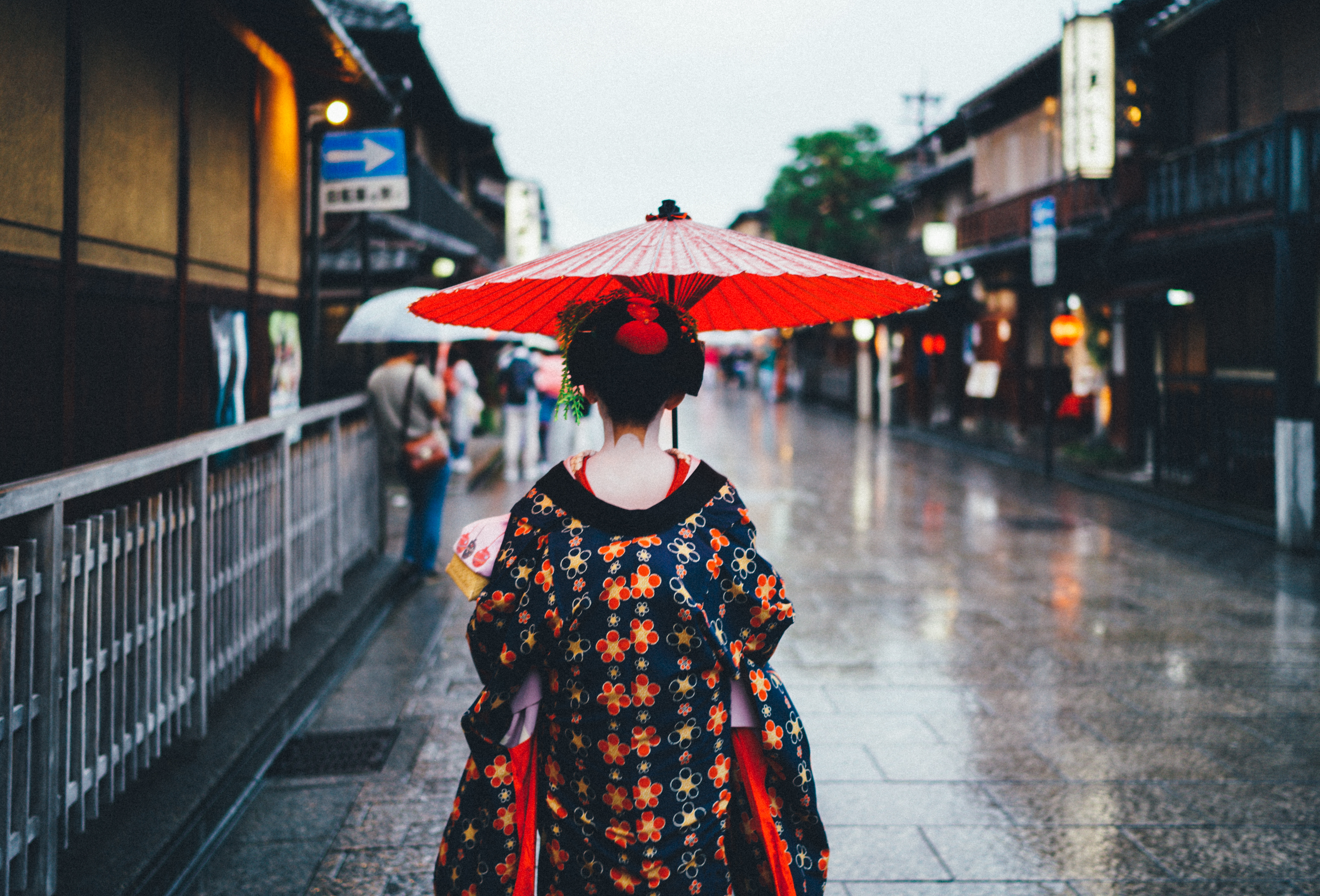 mulher asiática caminhando na chuva de Deus nos traduz